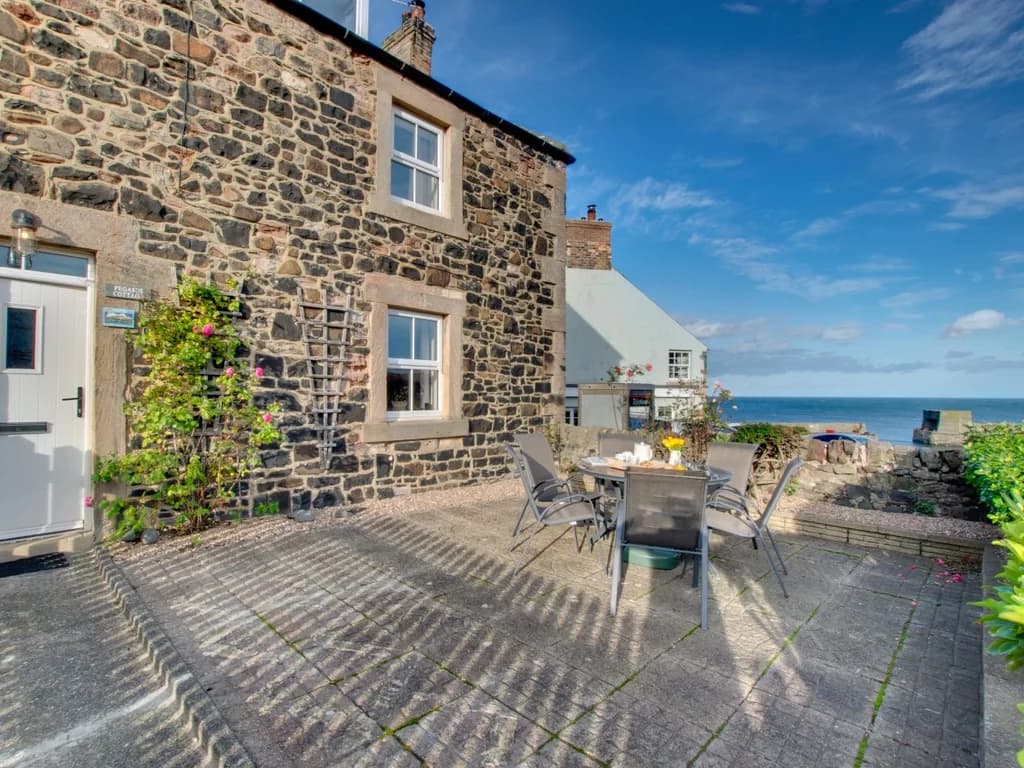 Outdoor seating with charming coastal views from Pegasus Cottage.