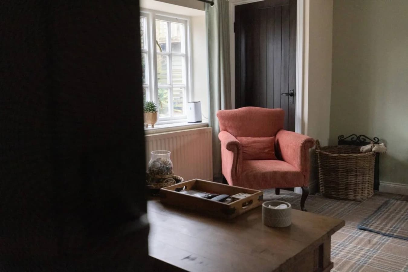 Fireside reading corner with upholstered armchair and log basket