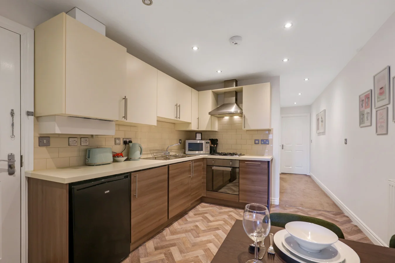 Fully equipped kitchen with cream cabinetry and walnut-effect units