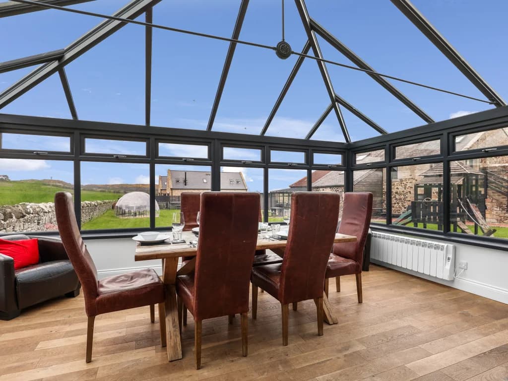 Conservatory dining area with countryside views and leather seating