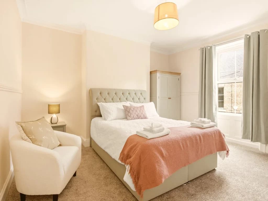 King bedroom with upholstered headboard and soft neutral décor.