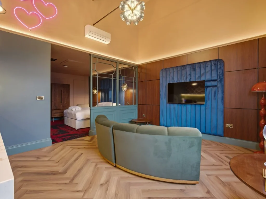 Open-plan living area with curved sofa, Smart TV and bedroom beyond.