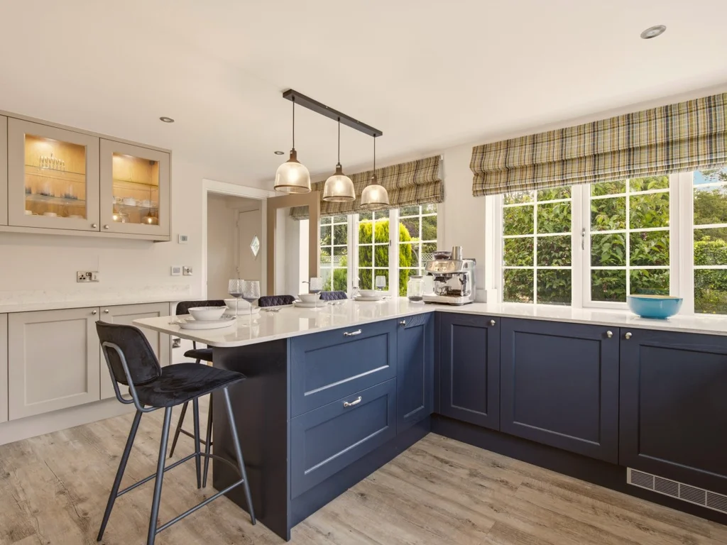Contemporary kitchen with navy cabinetry, breakfast bar and garden views