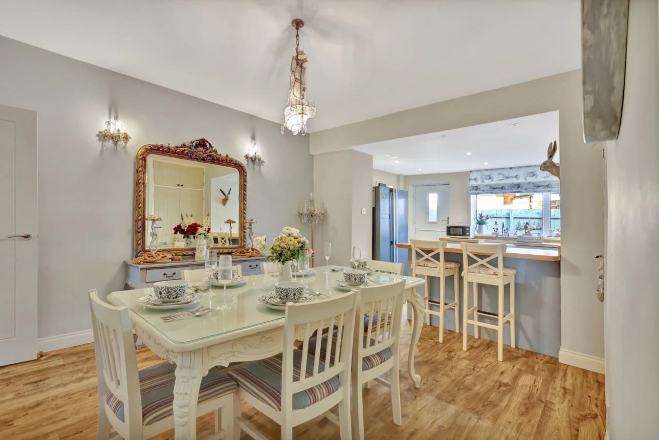 Dining area with chandelier lighting and open-plan kitchen beyond