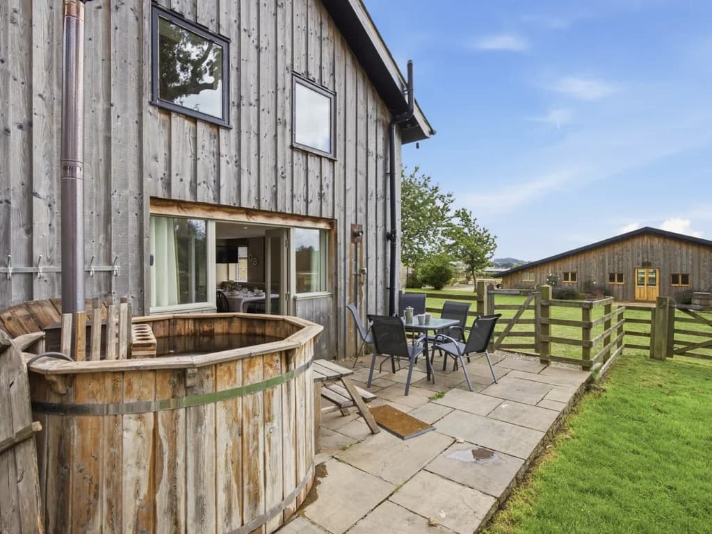 Patio with wood-fired Scandi hot tub and outdoor dining furniture