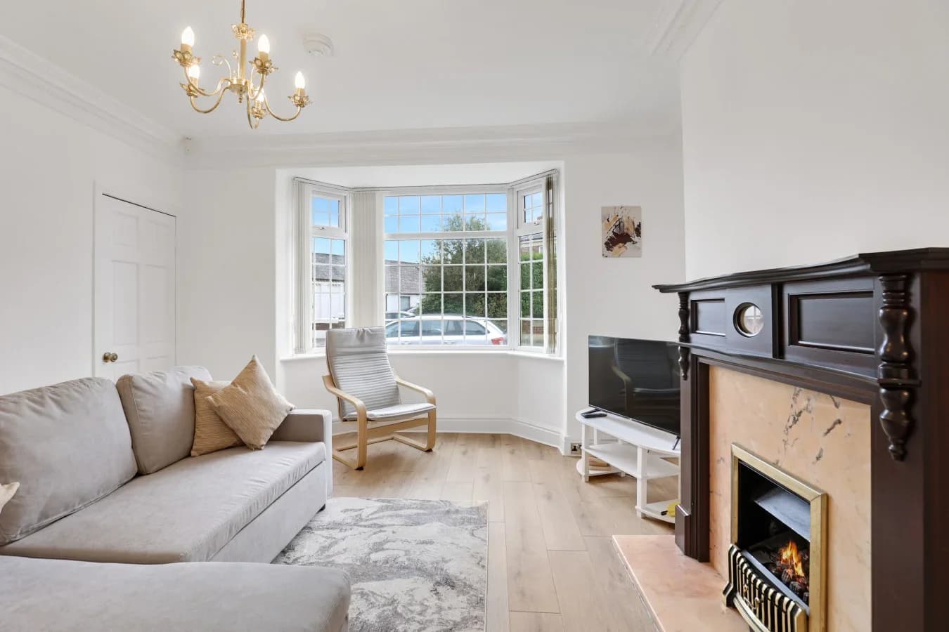 Bright living room with bay window, fireplace and comfortable seating
