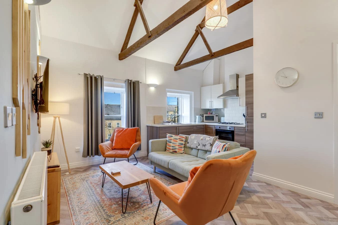 Bright lounge space blending contemporary comfort with original roof timbers