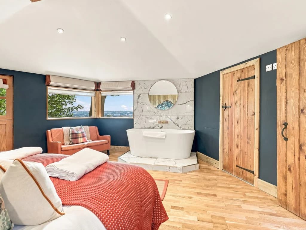 Super king bedroom with freestanding bath and countryside views