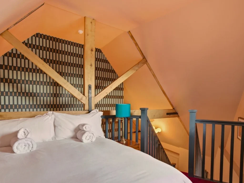 Cosy mezzanine bedroom with double bed and exposed timber beams