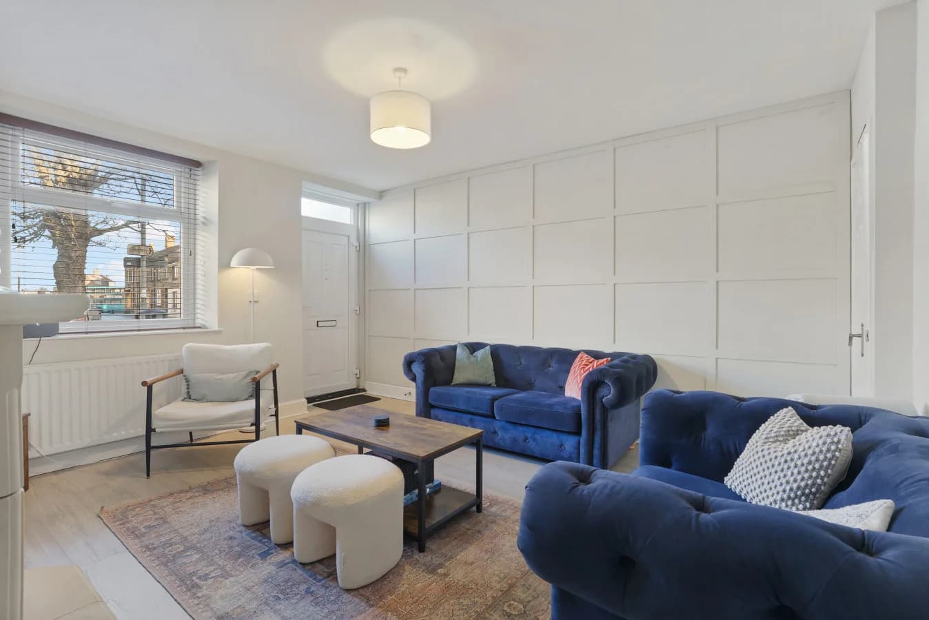 Elegant lounge with deep blue sofas, panelled walls and soft lighting