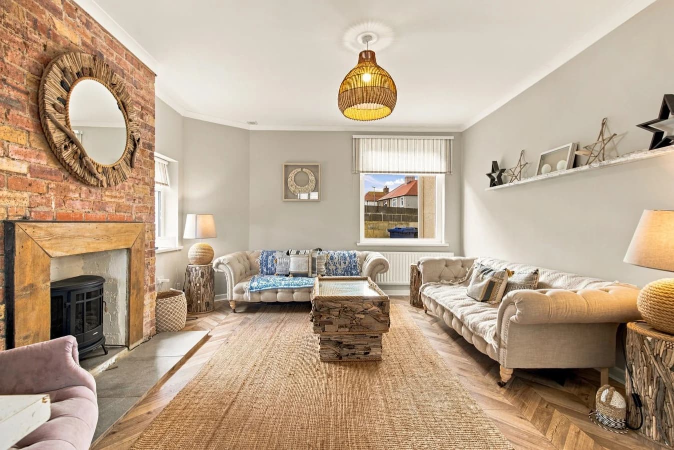 Spacious lounge with wood-burning stove and three comfortable sofas.