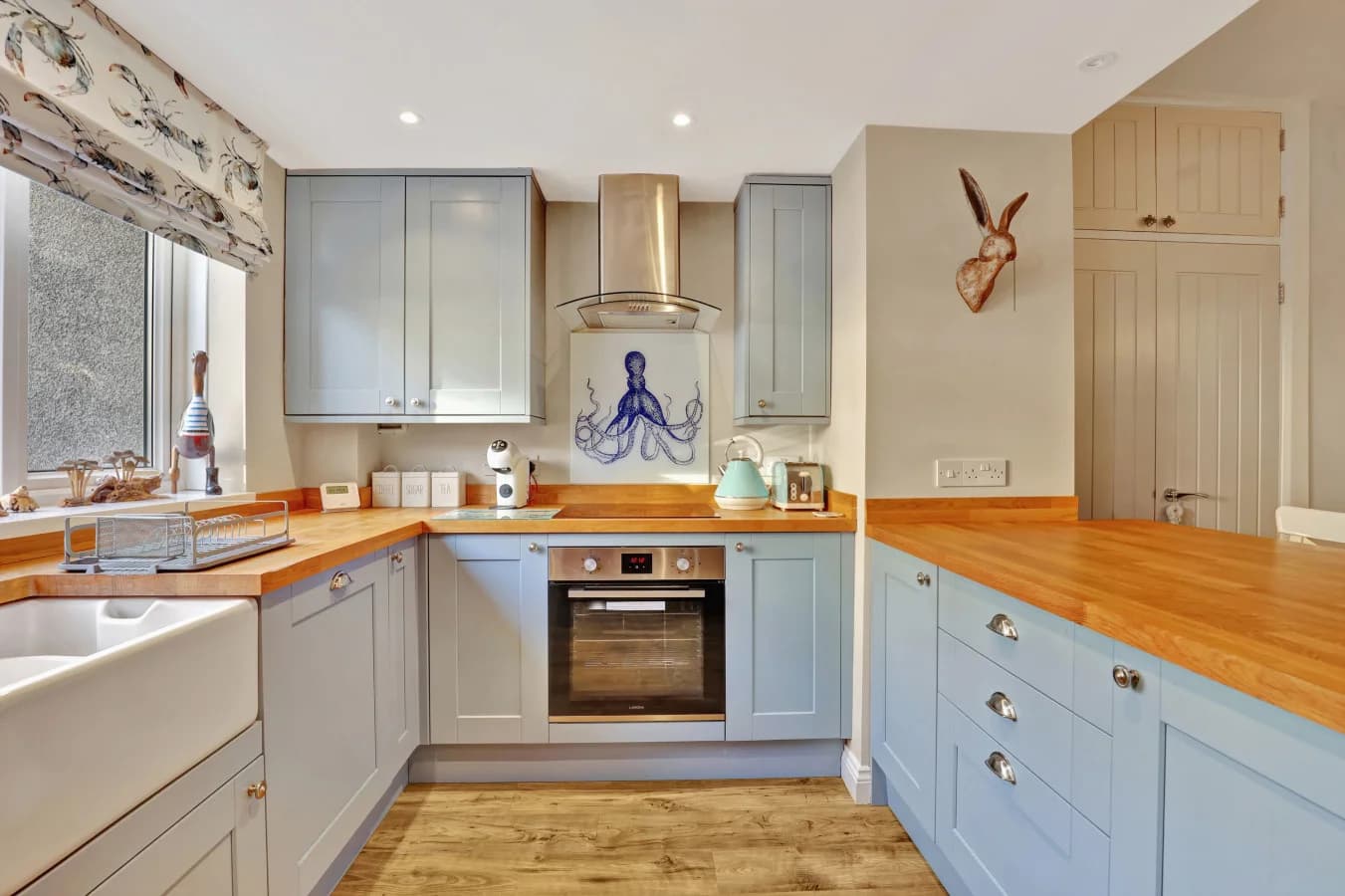 Country-style kitchen with Belfast sink and integrated appliances