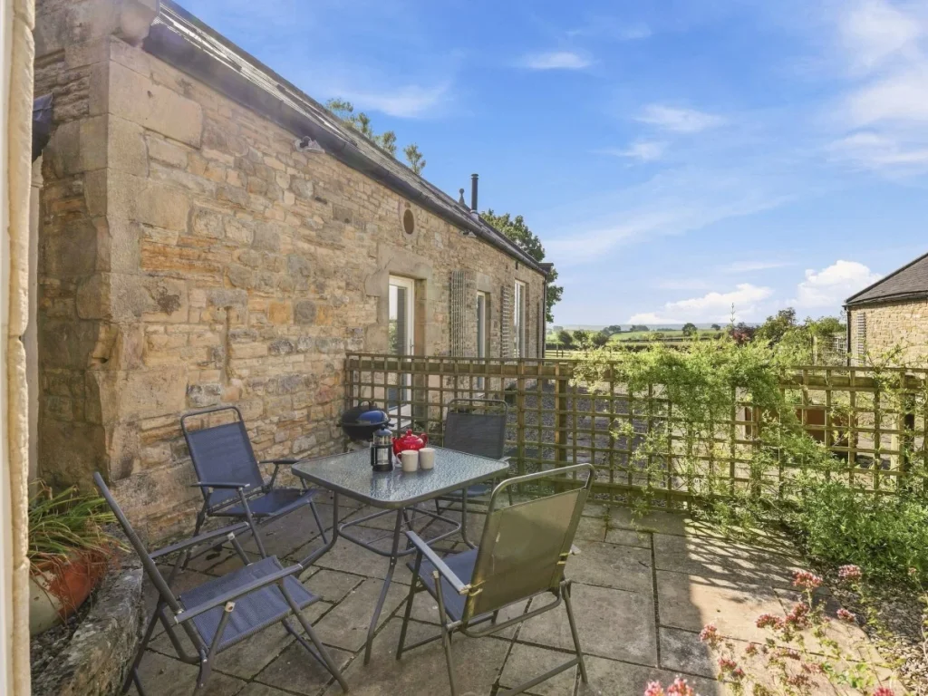 Private courtyard with outdoor seating and countryside views