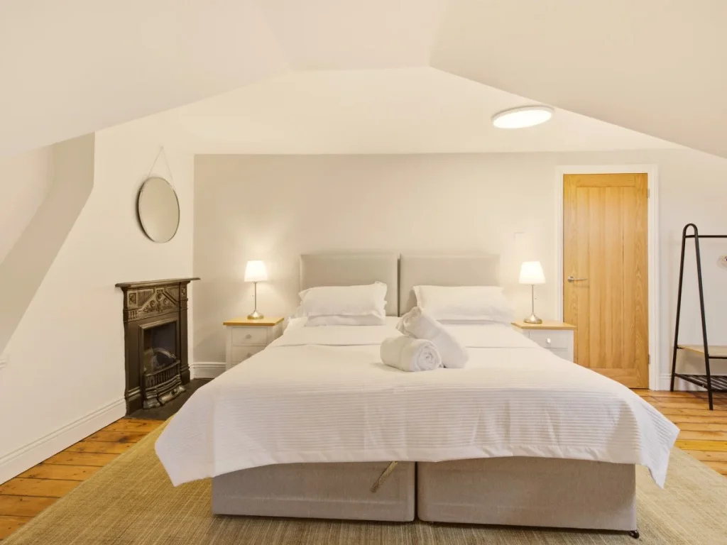 Super king-size bedroom with bedside lamps, mirror and hanging rail