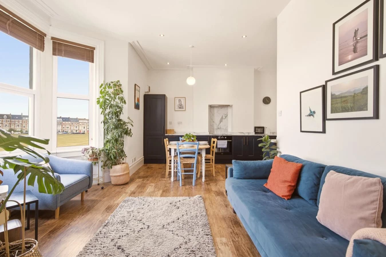 Open-plan living, dining and kitchen with large bay windows.